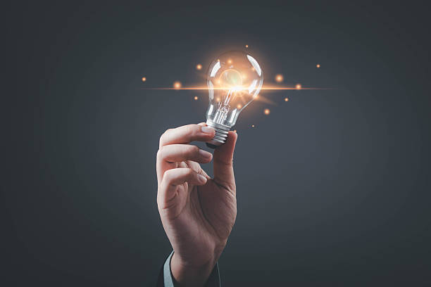 istock A hand holding a glowing light bulb, symbolizing ideas, inspiration, and innovation against a dark background. 2234304253