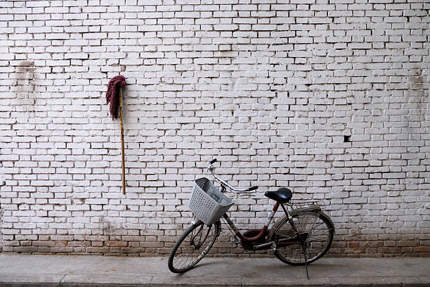 Bicycle and Mop Against White Wall Chengdu China. 2018. High quality photo