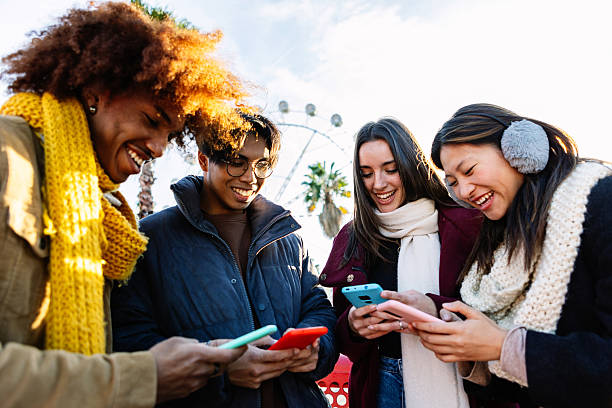 istock Young group of people in warm clothes using mobile phone device on winter 2234312988