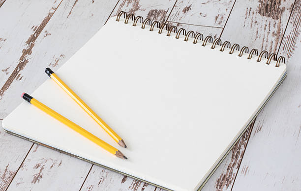 istock Blank Sketchbook Page with Two Pencils on Rustic White Wooden Table 2234313260