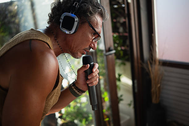 istock Mature man breathing into microphone wearing headphones 2234313348