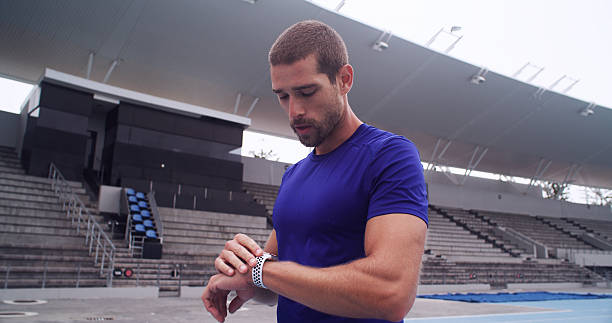 istock Man, athlete and smart watch at stadium with timer, stats and heart rate for performance training on track. Person, thinking and break with iot clock, stopwatch and fitness app for sport in Australia 2234316298