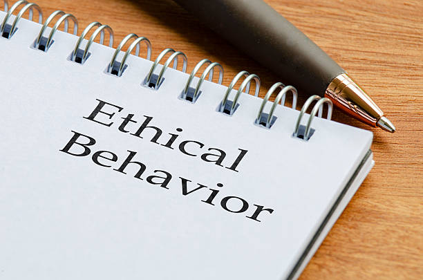istock Close up notepad with the words Ethical Behaviour written on a page placed on a wooden desk with a pencil beside it. 2234318439