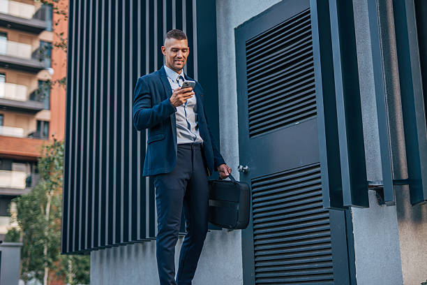 istock Businessman using smartphone outside office building 2234323558