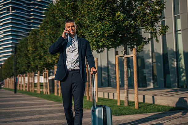 istock Businessman walking with suitcase and talking on phone 2234324706