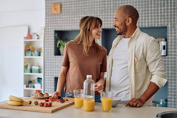 istock Happy couple preparing breakfast in kitchen looking each other 2234330276