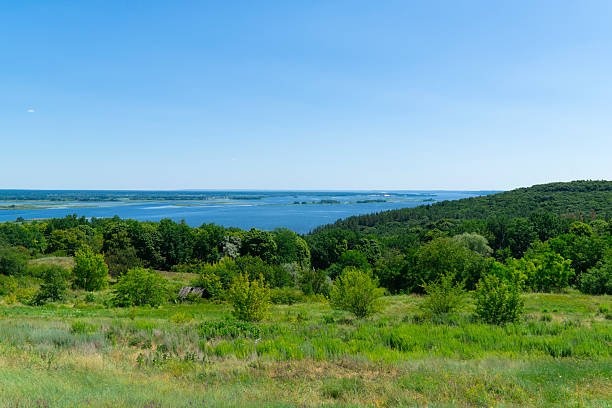 istock A wide river surrounded by green forests and hills under a blue sky 2234330916
