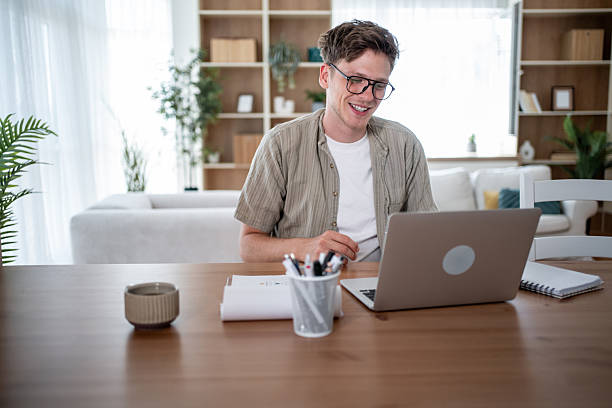 istock Young man working from home on laptop and smiling 2234331597