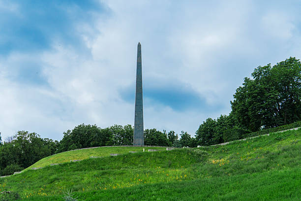 istock Obelisk monument on a green hill with a blue cloudy sky 2234333856