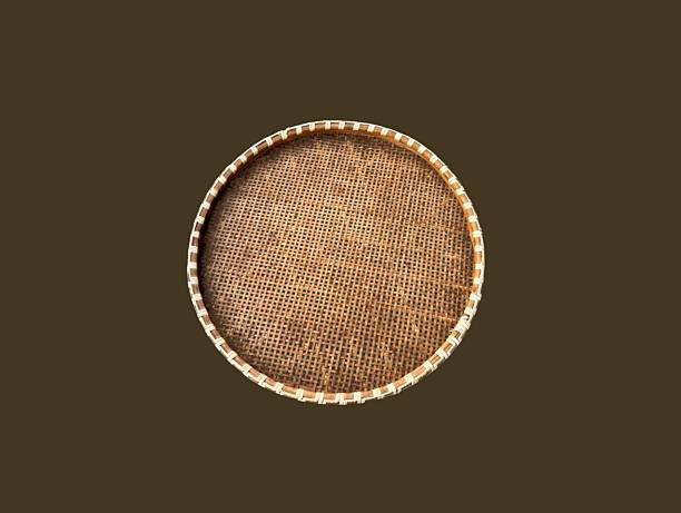 The brown background in the picture is a brown tray or winnowing basket woven from bamboo decorated with beautiful patterns. It is strong and sturdy. It is a circular tray used to hold various things.