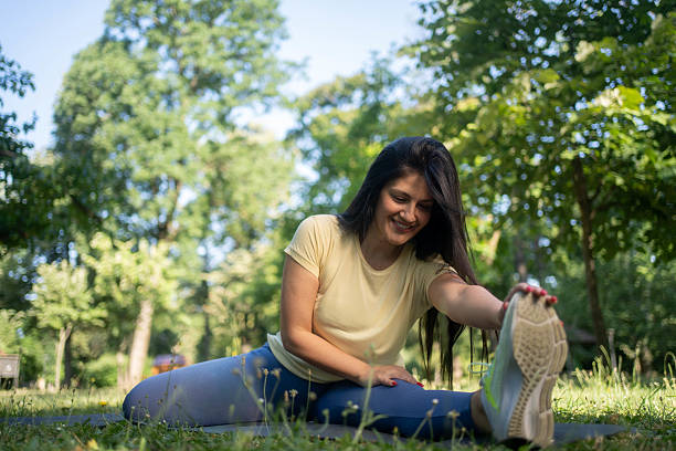 istock Smiling Fit Woman Stretching In Park 2234336344