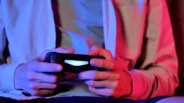 istock Close up of Hands Holding Gaming Controller during a Game Session 2234337680