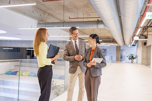 istock Smiling business people talking in modern office hallway 2234338188