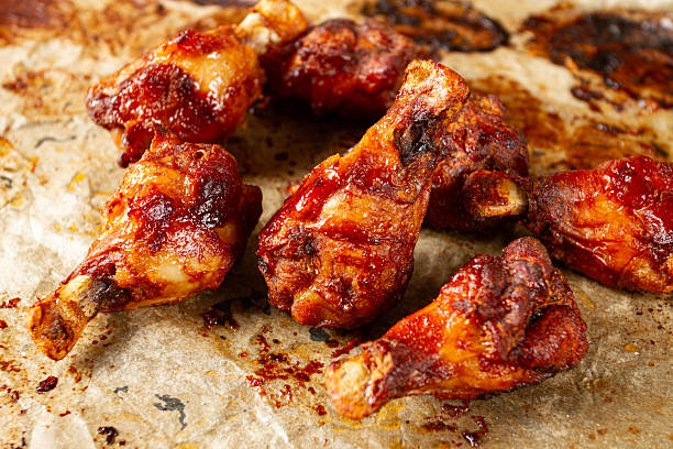 istock Grilled chicken legs lined with parchment paper and covered with caramelized glaze, close-up, 2234338762
