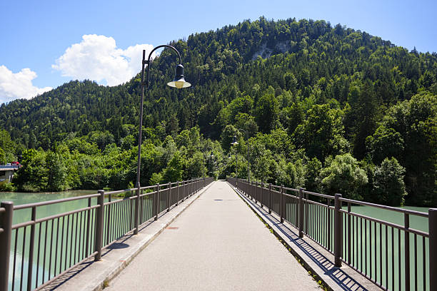 Pedestrian bridge leading to forested hills in Bavaria