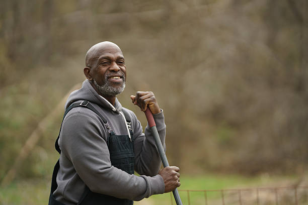 istock Smiling Gardener Outdoors Holding a Tool in a Peaceful Rural Setting 2234342826