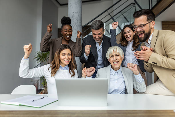 istock Excited business team celebrating success while looking at laptop 2234343917