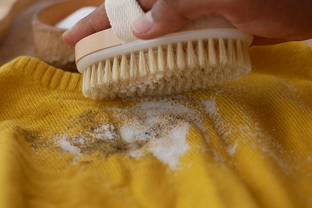 istock Caring for a yellow sweater using a brush and natural cleaner 2234343975