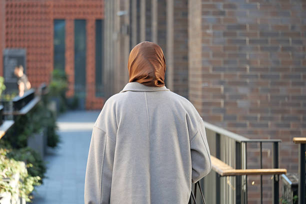 istock Woman walking in a modern urban setting with a brown scarf 2234347457
