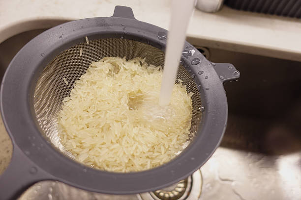istock Cooking rice by rinsing it in a colander over a sink 2234347812