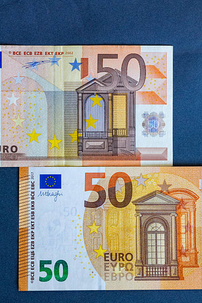 istock Close-up of two fifty euro banknotes placed on a graphite surface, showing the difference between the original 2002 design and the updated 2017 Europa series. The comparison highlights the evolution of European currency, financial security features, and m 2234348577