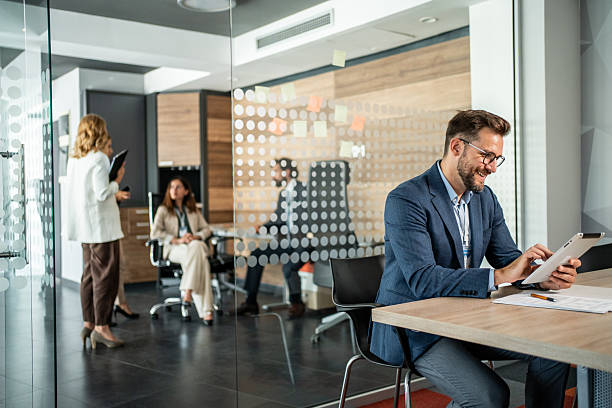 istock Businessman working on digital tablet in modern office with colleagues 2234354981