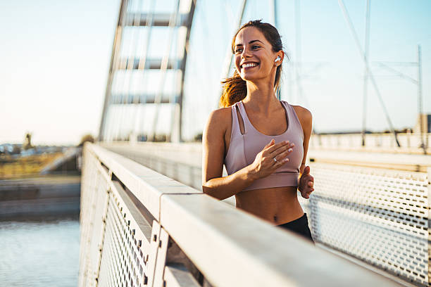 istock Smiling Woman Jogging on a Bridge During a Sunny Day 2234365738