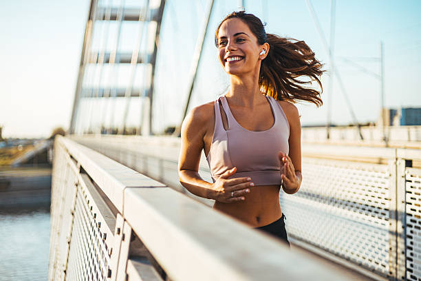 istock Happy Woman Jogging on a Bridge During a Morning Workout 2234365758