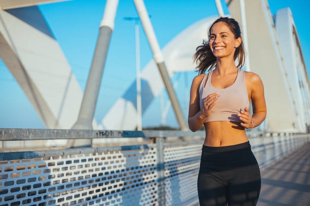 istock Smiling Woman Jogging on a Modern Bridge During a Sunny Morning 2234365773