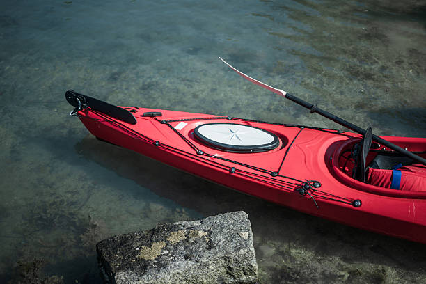 Top view of red kayak resting on shore.