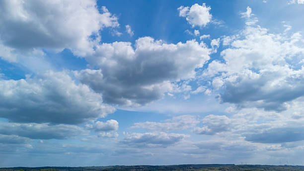 istock A vast blue sky filled with fluffy white clouds stretches above a serene landscape, creating a peaceful atmosphere ideal for nature-themed projects and outdoor inspirations. 2234368838