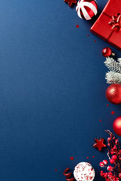 istock Elegant Christmas composition with red gift box, pine branches, stripped baubles on dark blue vertical background. Flat lay, top view. 2234370175
