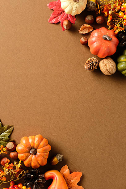 istock Autumn vertical flat lay with pumpkins, fall leaves, walnut, acorns on brown background. Top view with space for text. 2234370715