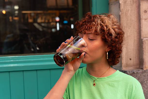 Young woman enjoying a refreshing drink on a summer day