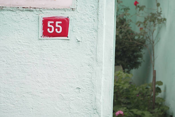 istock House number 55 displayed on a painted wall in a garden area 2234373751