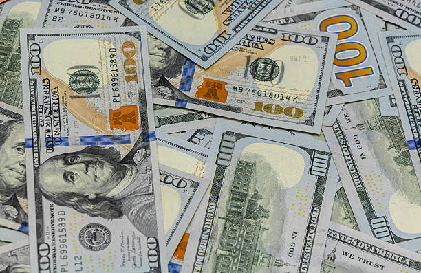 istock Scattered hundred dollar banknotes close-up background 2234373796