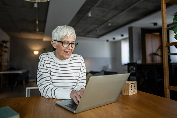 istock Senior adult woman working from home using laptop computer 2234376394