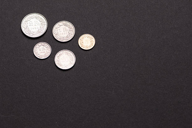istock Swiss franc coins on a dark background 2234376680