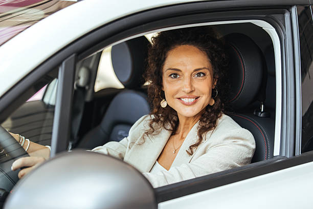 istock Confident Woman Smiling While Driving a Modern Vehicle In a City Environment 2234378082
