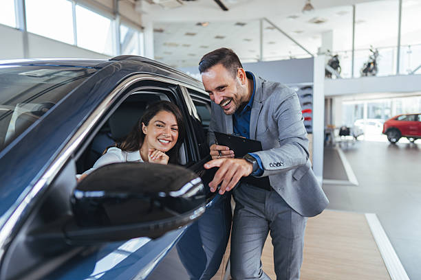 istock Smiling Customer and Representative Interacting in a Modern Car Showroom 2234378137