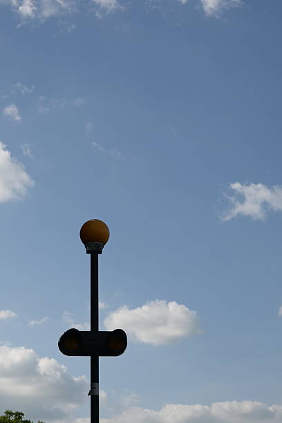 A visually striking traffic signal stands out against a vibrant blue sky filled with soft clouds