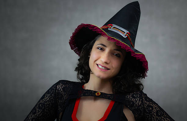 istock Beautiful witch in black and red costume, smiling and looking at camera. 2234381005