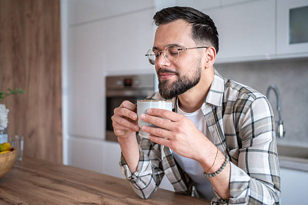 istock Young man enjoying a cup of coffee in his modern kitchen 2234382722