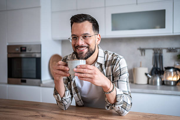 istock Smiling man enjoying a cup of coffee in his modern kitchen 2234382751