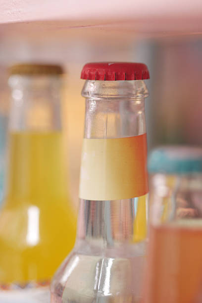 Bottles filled with various flavored drinks are displayed on a shelf.