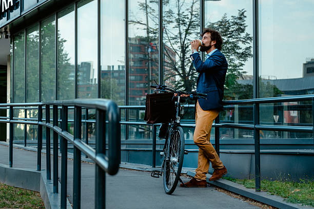 istock Executive in Suit Drinking Coffee by Bicycle Near Corporate Building 2234383768