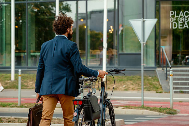 istock Bearded Professional in Suit Pushing Bicycle Near Corporate Office 2234383845