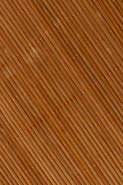 A close-up view of a warm brown bamboo mat, showcasing a woven texture that adds an organic feel to home decor and creates a cozy atmosphere.