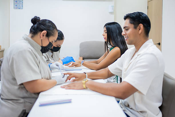 Mexican couple receiving manicures from two beauticians stock photo
