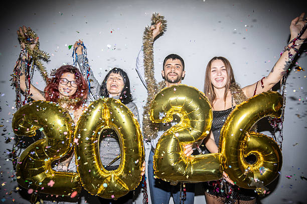 istock Joyful group holding 2026 balloons amidst falling confetti, happy 2234399760